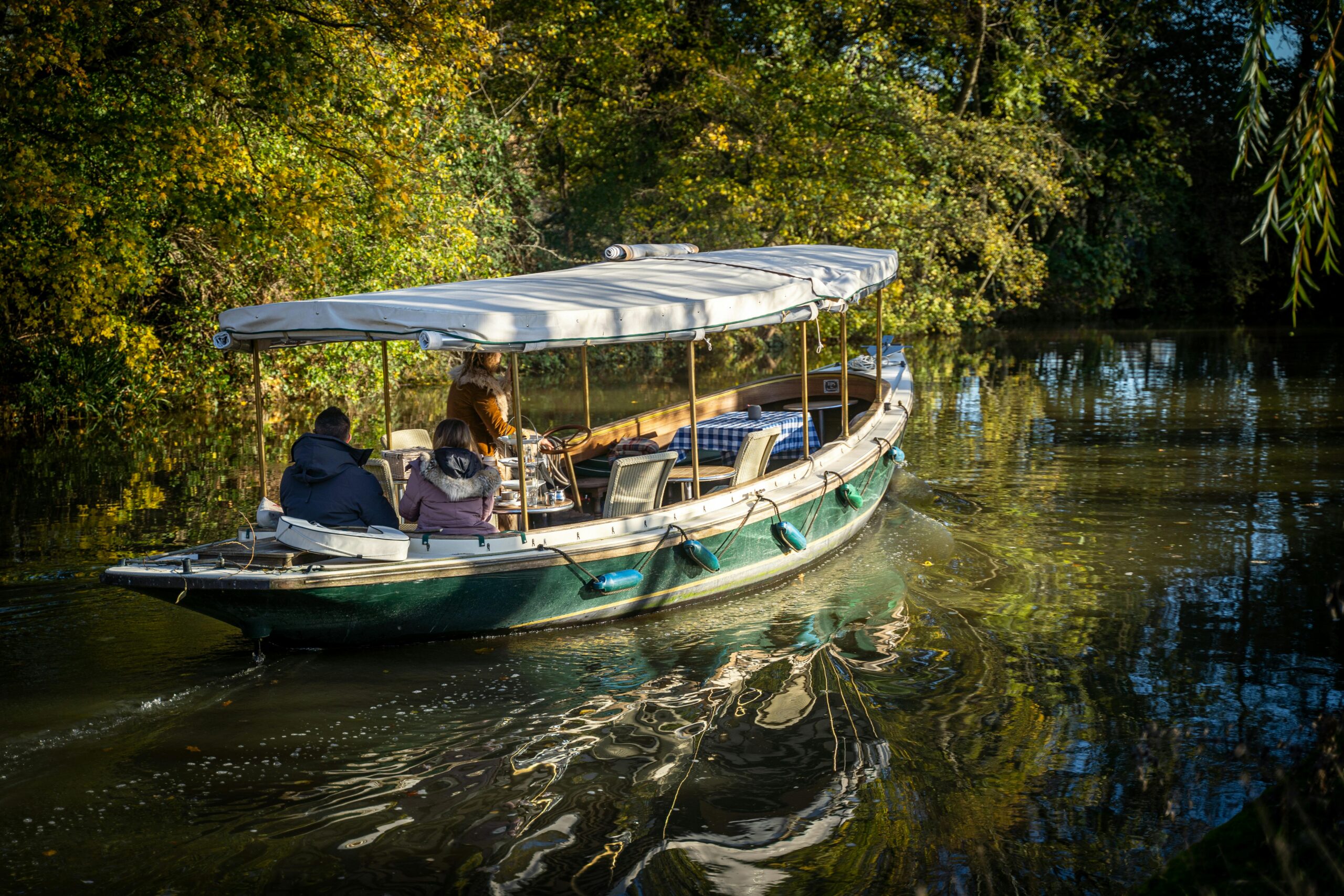 Enjoy a serene boat ride along Oxford's picturesque canal surrounded by autumn foliage.