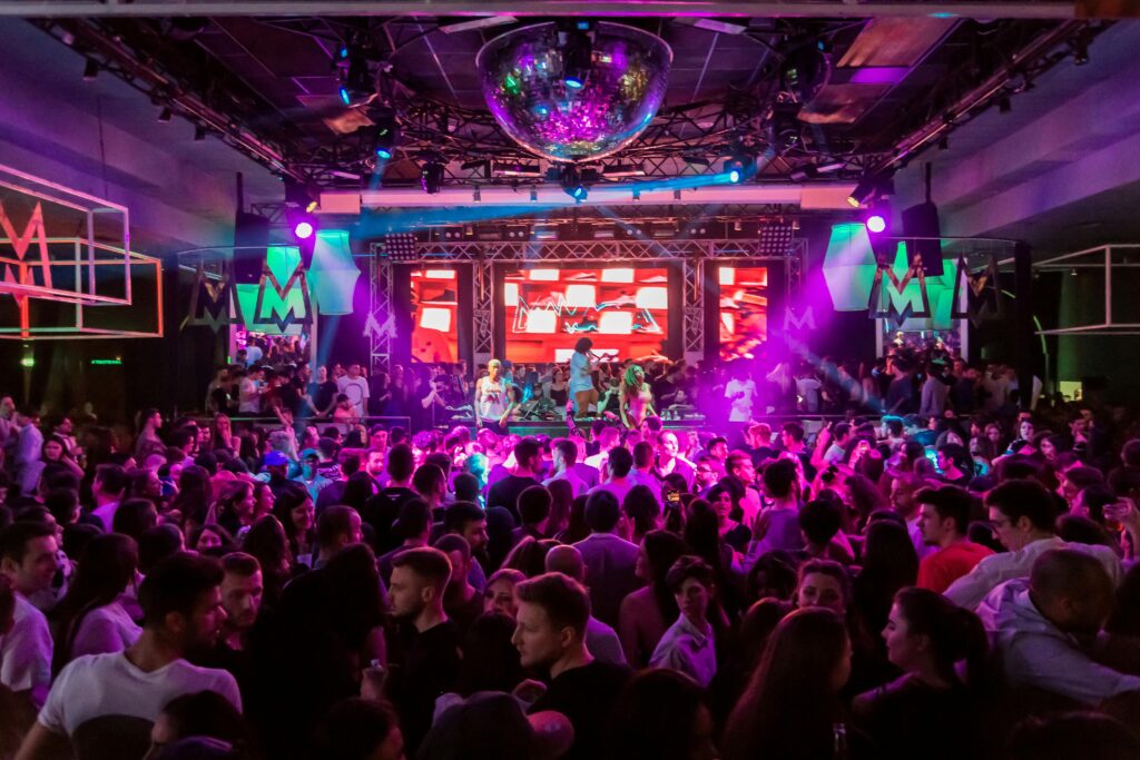 Dynamic crowd at a lively nightclub in Mantua, Italy, with vibrant lights and energetic atmosphere.